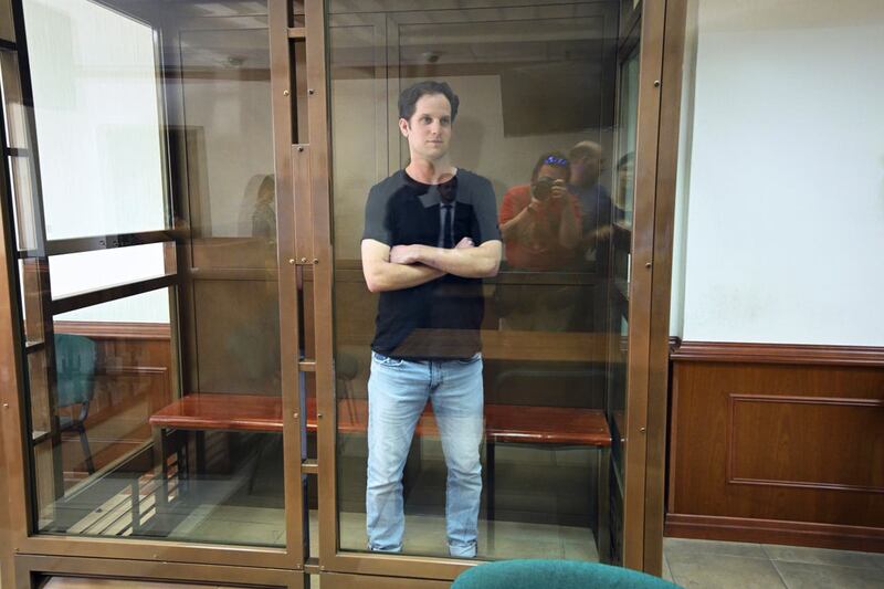 Wall Street Journal reporter Evan Gershkovich stands in a glass cage in a courtroom at the Moscow City Court