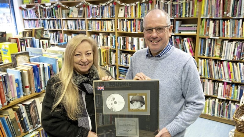Concern shop volunteer Jim Henry with Maggie Mooney and one of the U2 albums 