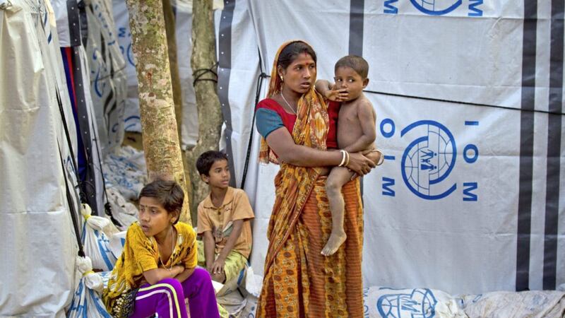 A Rohingya Hindu refugee stands outside her makeshift shelter with her children, near Kutupalong refugee in Bangladesh 