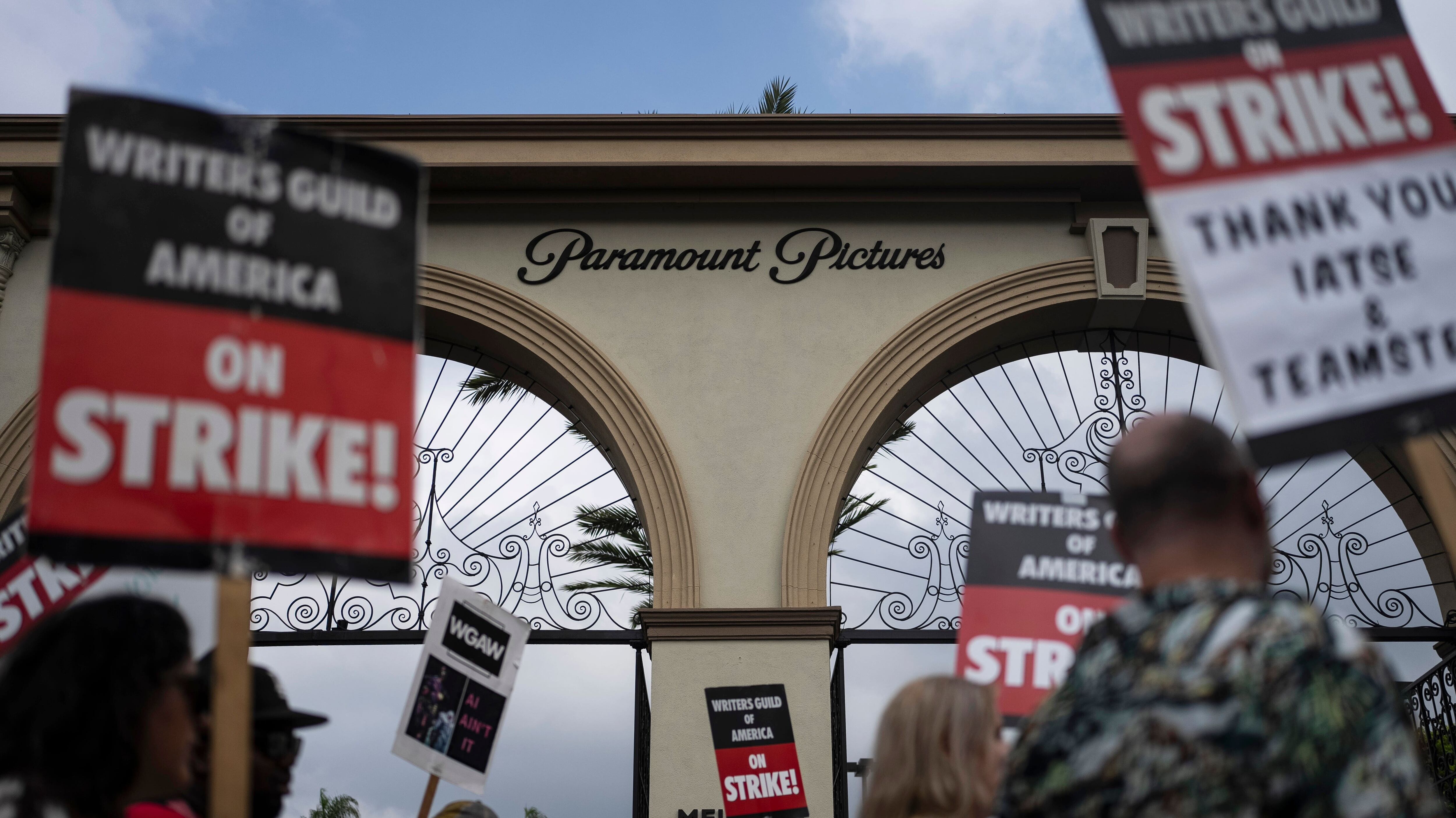 Demonstrators walk with signs during a rally outside the Paramount Pictures Studio in Los Angeles on Thursday (AP)