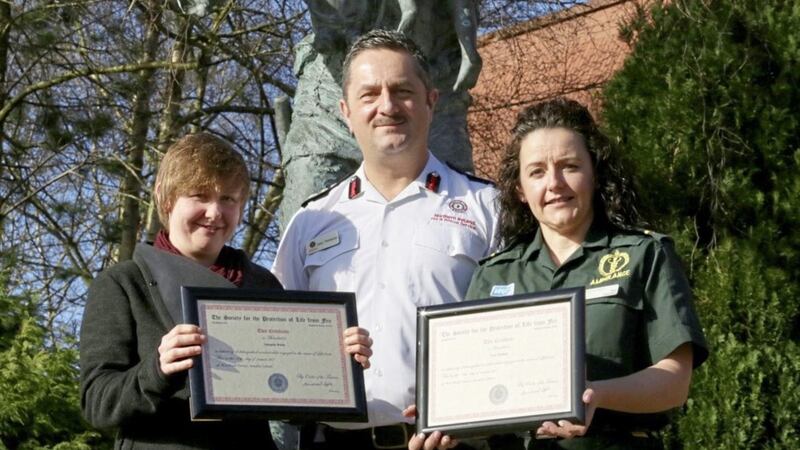 Gary Thompson from the NIFRS presented certificates of bravery to Amanda White (left) and paramedic Tara Wallace for their rescue of a woman from a house fire in Annahilt 