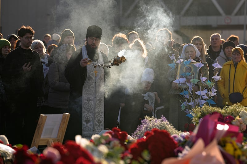 An Orthodox priest conducts a service at a makeshift memorial in front of the Crocus City Hall (Alexander Zemlyanichenko/AP)