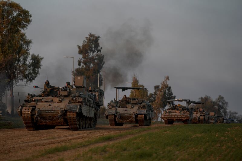 A convoy of Israeli army armoured personnel carriers moves near the Israeli-Gaza border, in southern Israel (Leo Correa/AP)
