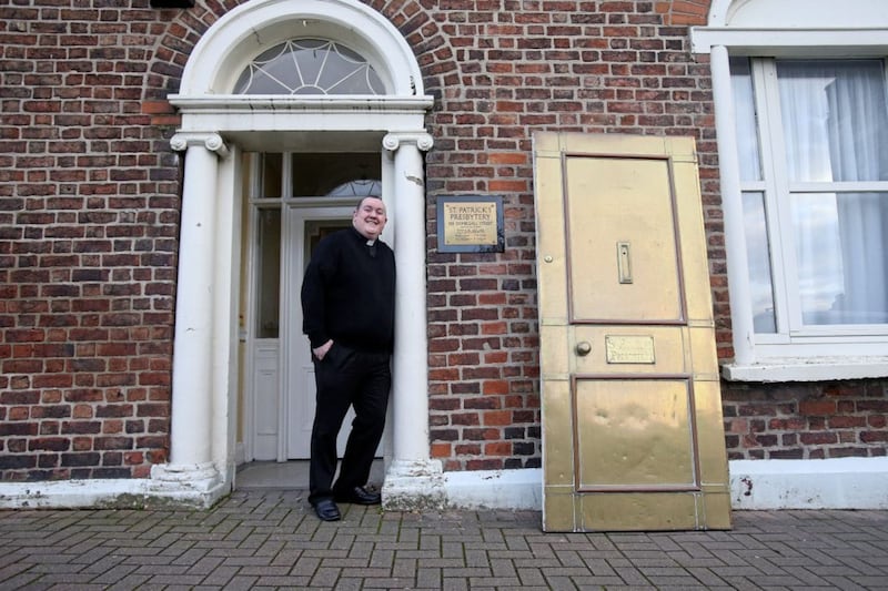 Fr Tony McAleese oversees the removal of the iconic brass door from St Patricks Presbytery in Donegall Street, the door will be refurbished and put back in place later in the week Picture Mal McCann. 