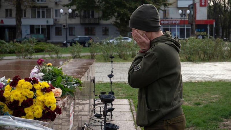 A Ukrainian servicewomen cries as she lays flowers to commemorate those killed in the war, in Kherson (Efrem Lukatsky/AP)