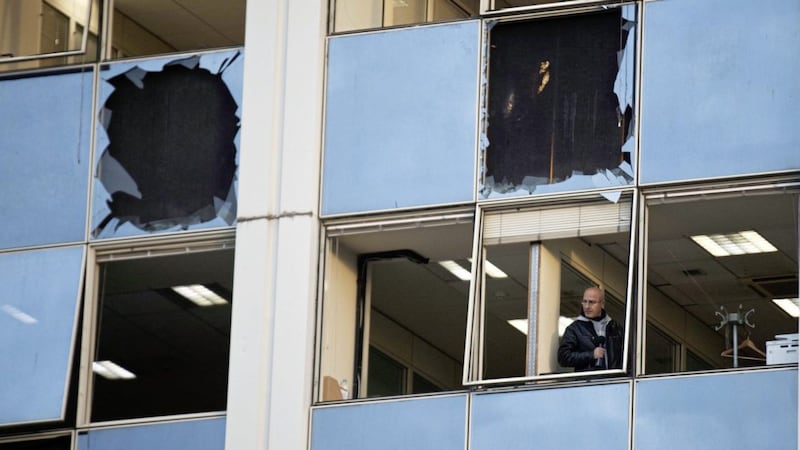 A journalist looks out of a broken window after a powerful bomb exploded outside private Greek television station Skai in Faliro, near Athens. Picture by AP Photo/Petros Giannakouris 