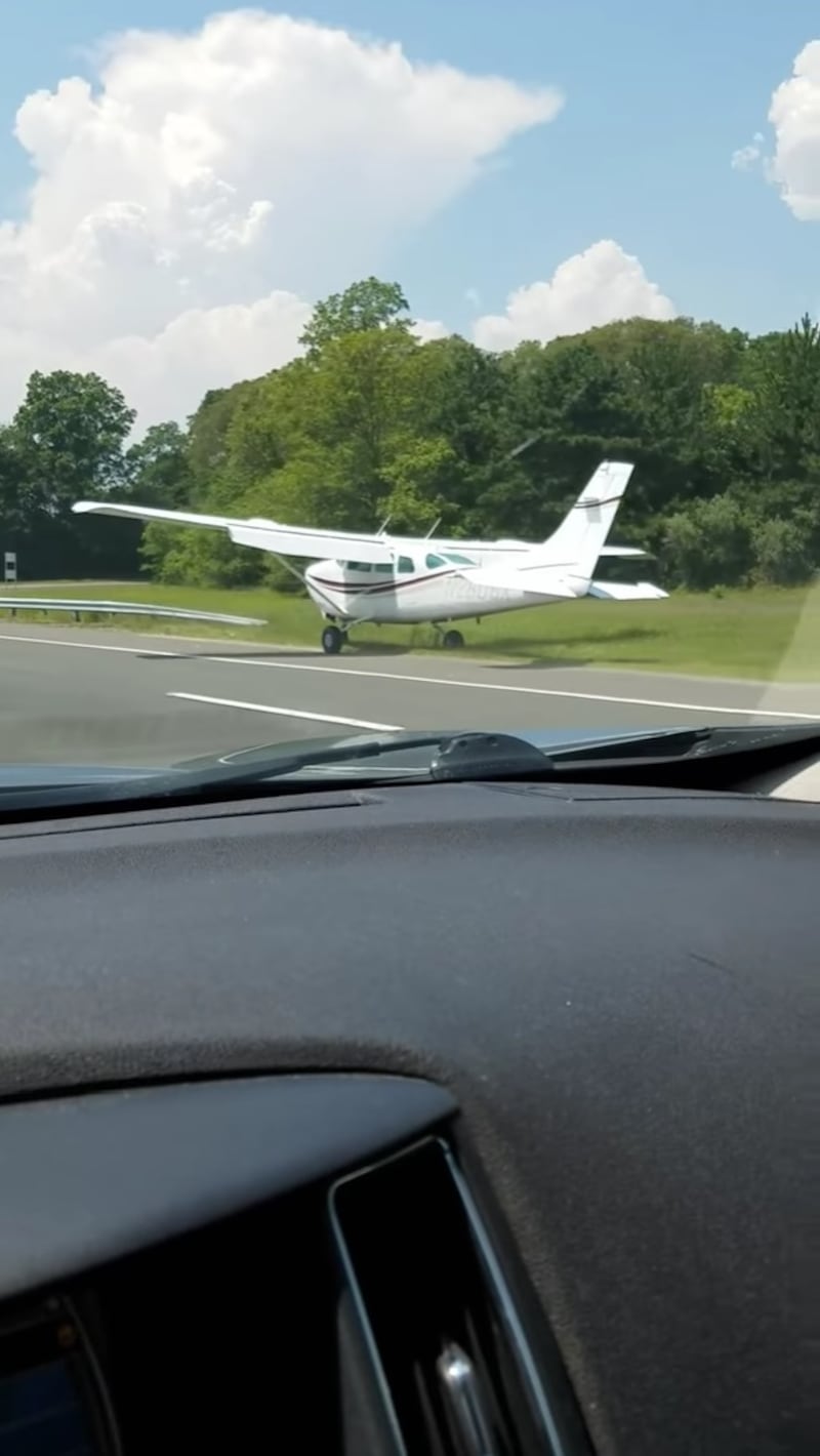 Driver catches plane landing on a New York freeway.
