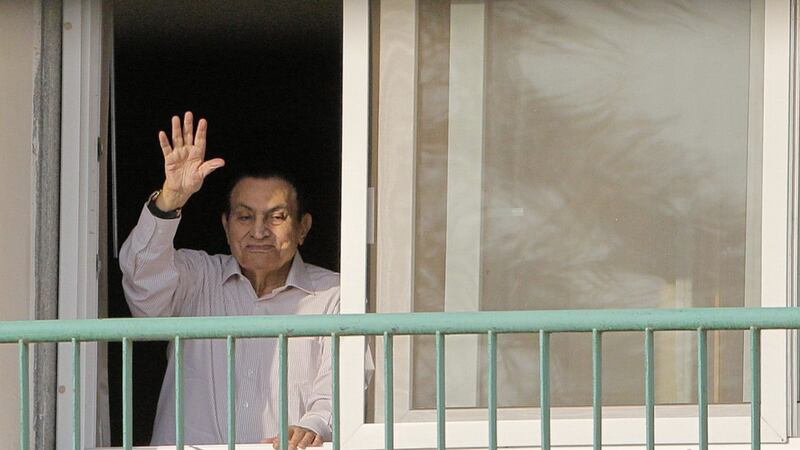 Ousted Egyptian president Hosni Mubarak waves to his supporters from his room at the Maadi Military Hospital as they celebrate the 43rd anniversary of the Oct. 6, 1973 war 