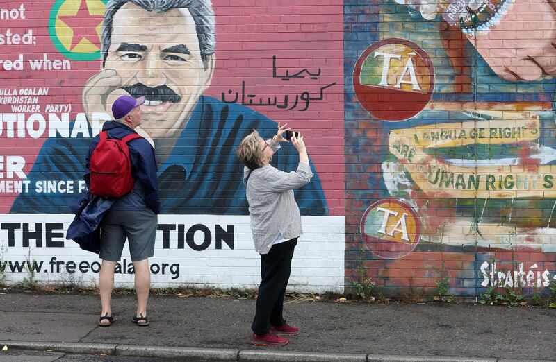 Tourists visit the international mural wall on the Falls Road, west Belfast. PIcture Mal McCann