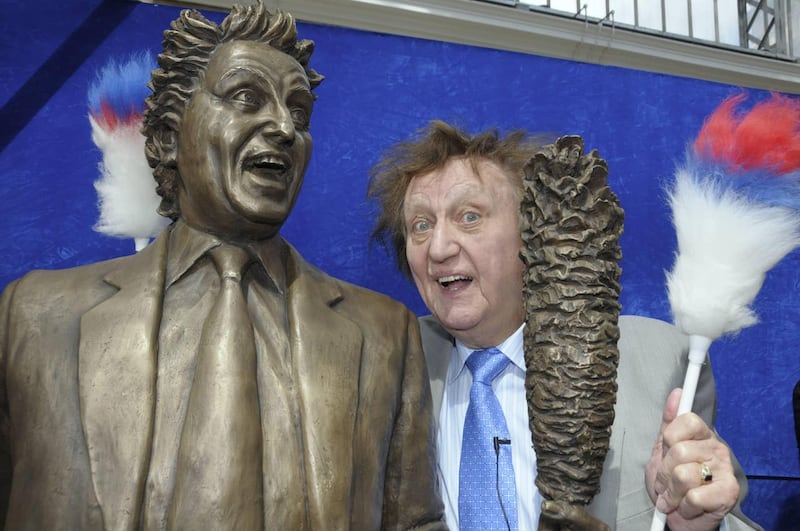 Ken Dodd poses with a bronze statue of himself