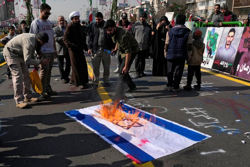 Demonstrators in Tehran burn a representation of the Israeli flag during the annual rally commemorating Iran’s 1979 Islamic Revolution (Vahid Salemi/AP)