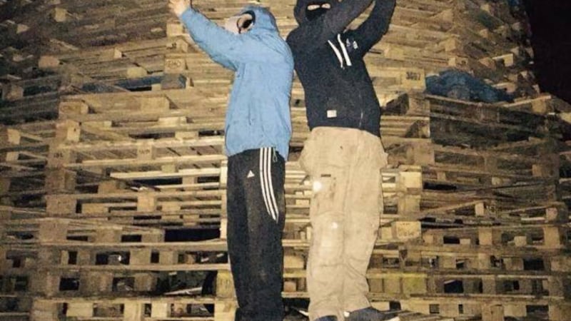 Teenagers pose with guns at the anti-internment bonfire in Beechmount in west Belfast. 