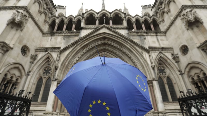 A person under an umbrella carrying the EU flag outside the High Court in London yesterday. Picture by Yui Mok, Press Association 