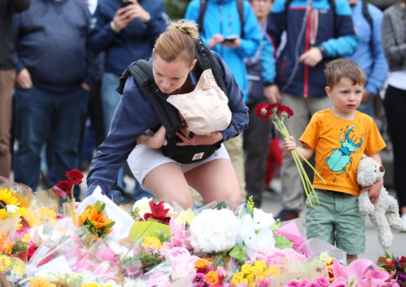 A child with his mother laying flowers