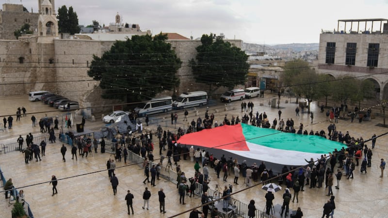 People hold a giant Palestinian flag in Manger Square (AP)