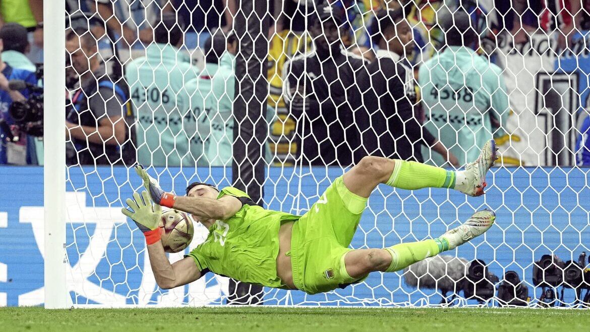 Argentina goalkeeper Emiliano Martinez saves a penalty kick from France&#39;s Kingsley Coman in the penalty shoot-out after extra time during the World Cup final in Qatar in December 