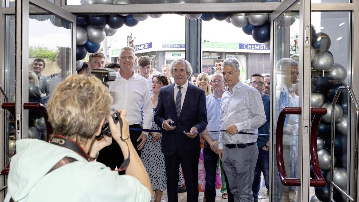 PICTURE THIS: Pat Jennings cuts the ribbon to formally reopen Louis Boyd Menswear at Mill Street in Newry, watched by the company&#39;s senior directors 