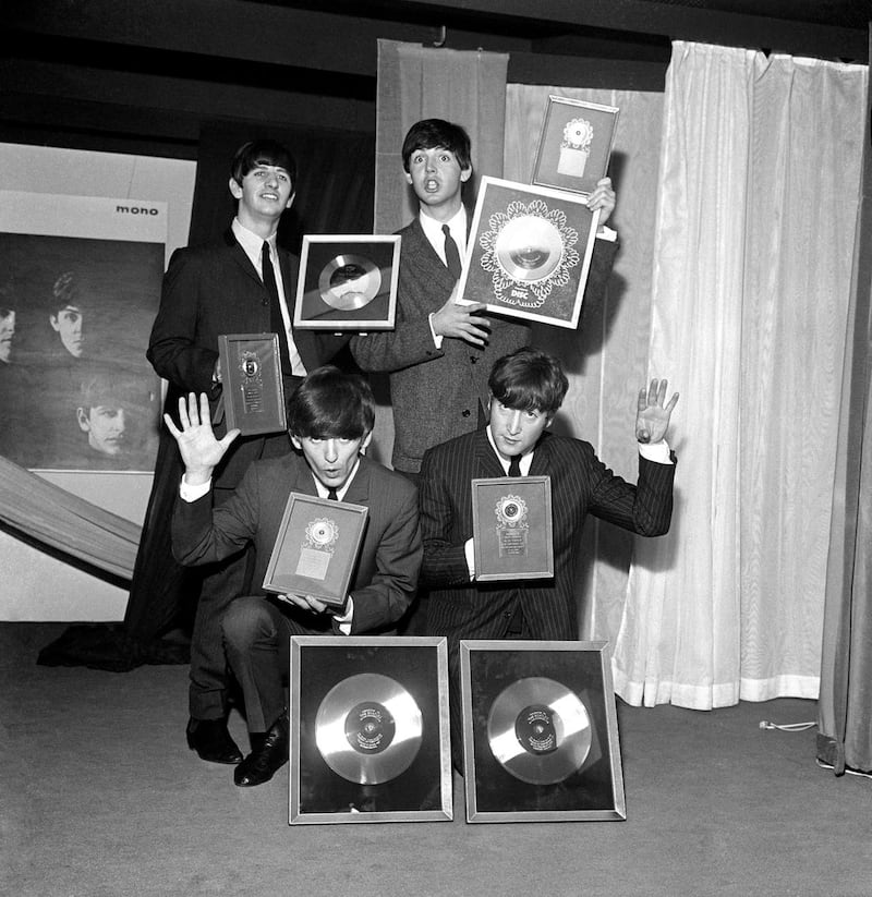 The Beatles pictured with silver discs awarded for sales of their albums Please Please Me and With the Beatles. (Image: PA)