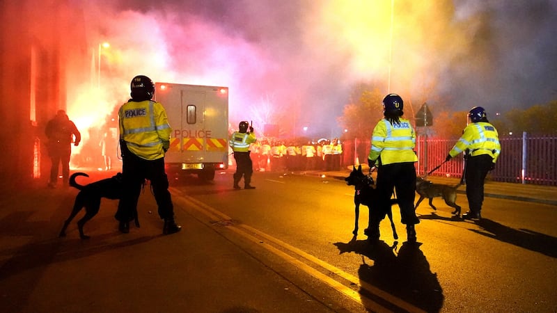 Police officers with dogs as flares are set off outside the stadium before the UEFA Europa Conference League Group E match at Villa Park, Birmingham (David Davies/PA)