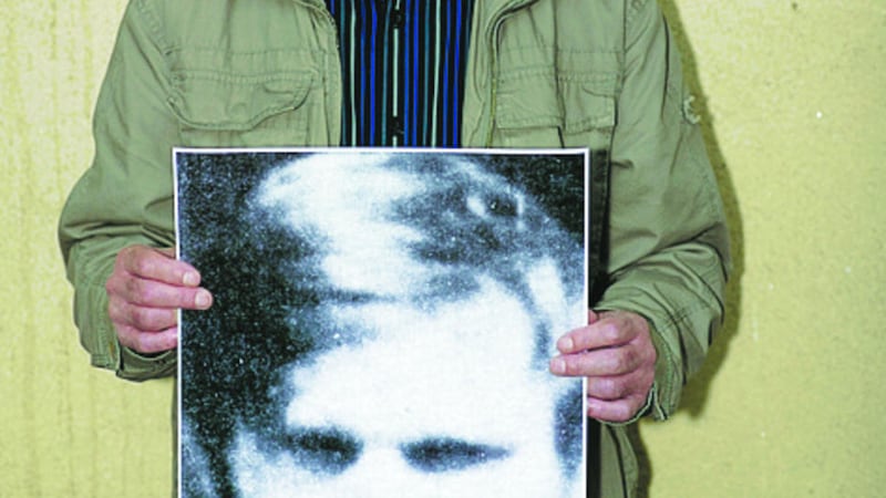 Liam Wray holds a photograph of his murdered brother Jim Wray 