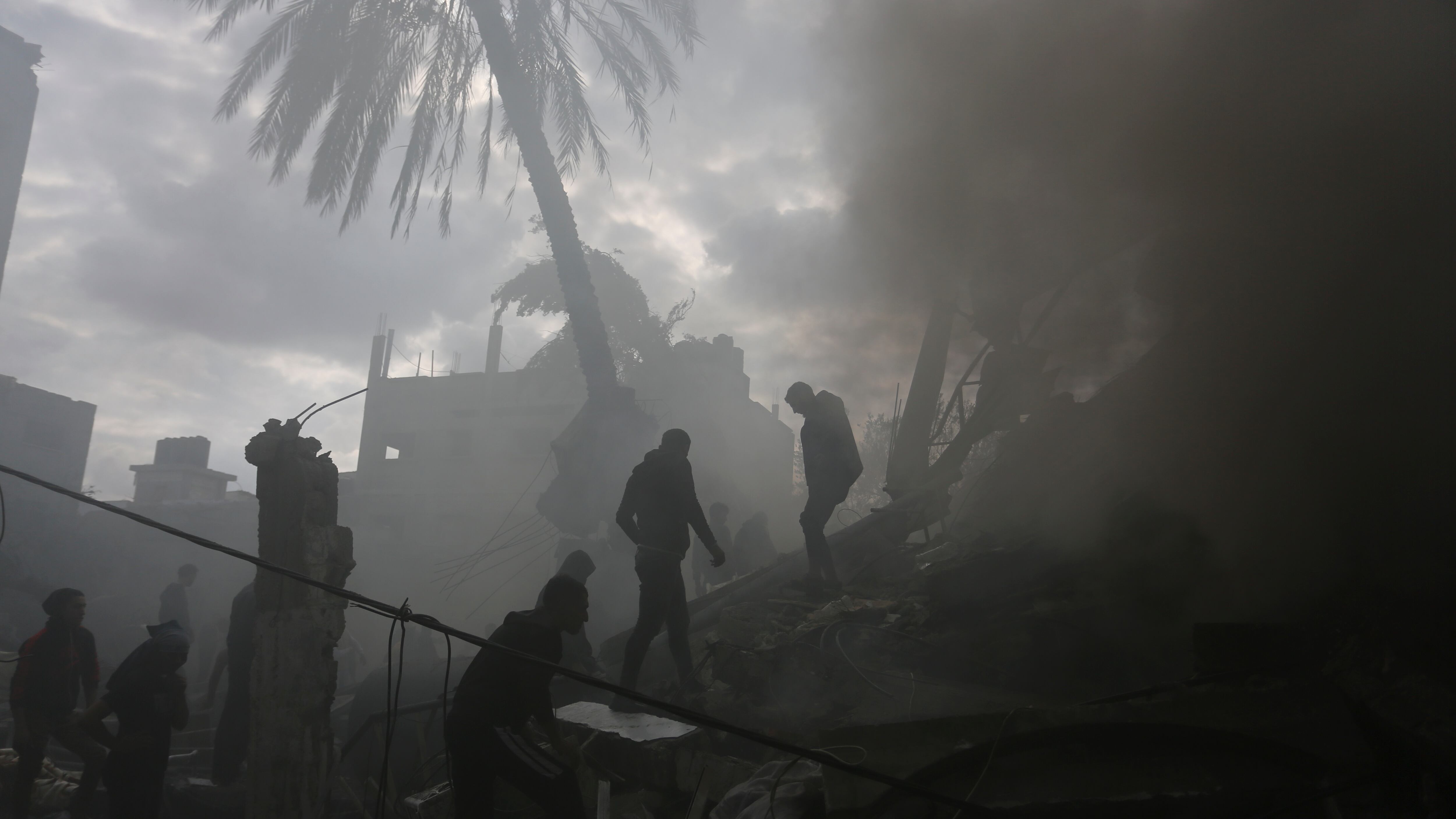 Palestinians look for the survivors of an Israeli strike in Rafah, Gaza Strip, on Thursday (Hatem Ali/AP)