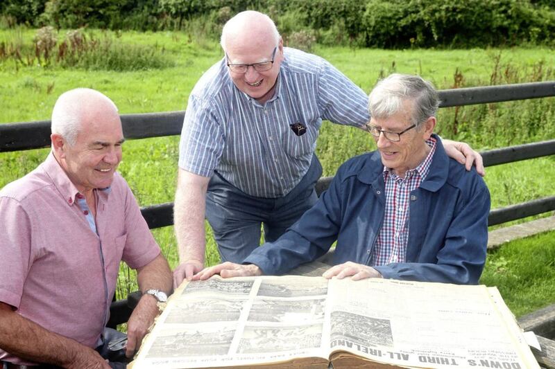 Mickey Cole, Peter Rooney and Dan McCartan look over the Irish News file from September 22, 1968 - the day they helped Down to a third All-Ireland title that decade. Picture by Mal McCann 