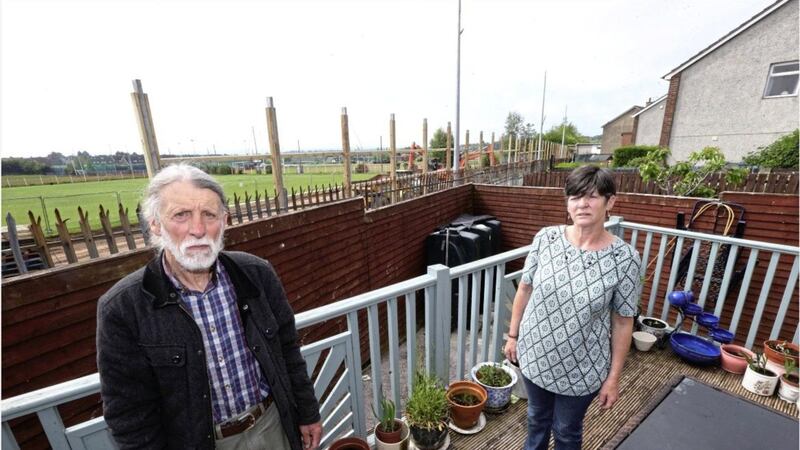 Patricia McParland and Jim Orr, residents of Corrib Drive in the Lenadoon area of west Belfast, who fear that new wooden fencing at St Paul&#39;s GAA club will ruin the view of the city from their homes. Picture by Hugh Russell 