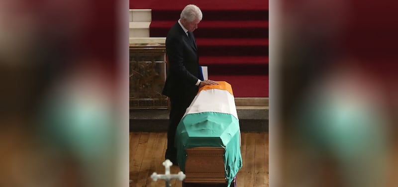 Former US President Bill Clinton touches the coffin during the funeral of Martin McGuinness at St Columba's Church Long Tower, in Derry&nbsp;