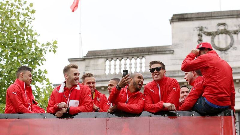 Arsenal&#39;s Theo Walcott (centre) joins his team-mates for a bus-top victory lap around north London on Sunday, a day after Arsenal retained the FA Cup at Wembley Picture: PA 