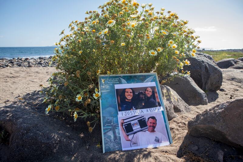 The photos of the foreign surfers who disappeared are placed on the beach in Ensenada, Mexico (Karen Castaneda/AP)