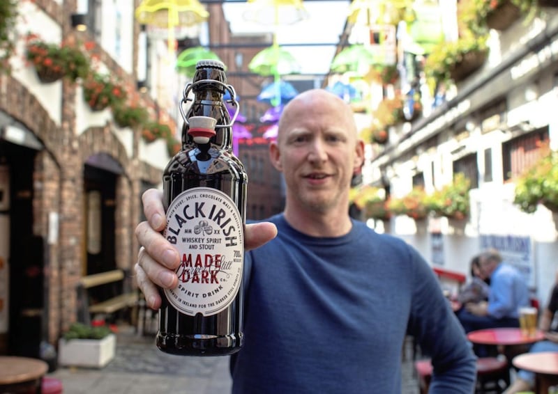 Richard Ryan displays his company&#39;s Black Irish Whiskey outside the Duke of York pub in Belfast. 