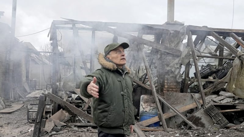 A man opens his arms as he stands near a house destroyed in the Russian artillery shelling, in the village of Horenka close to Kyiv, Ukraine last Sunday. Picture by AP Photo/Efrem Lukatsky. 