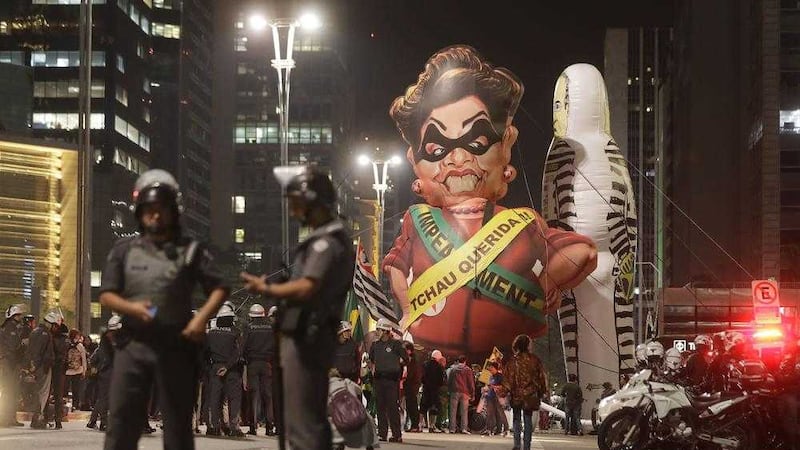 Police officers stand next to a large inflatable doll in the likeness of Brazil's President Dilma Rousseff wearing a presidential sash with the words in Portuguese &quot;Goodbye dear&quot; during a rally to celebrate her impeachment in Sao Paulo, Brazil. Picture by Andre Penner, Associated Press