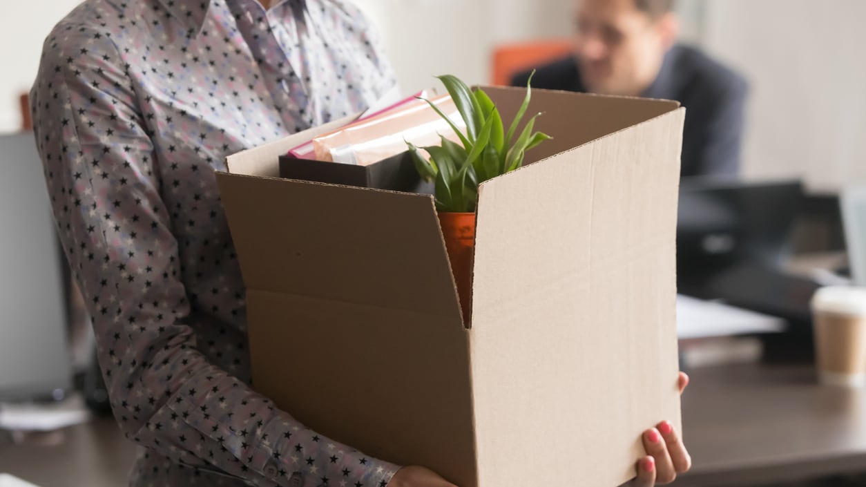 Close up view of new female employee intern holding cardboard box with belongings.