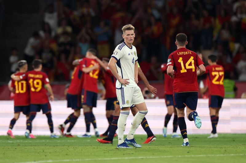 Scott McTominay looks dejected while Spain players celebrate