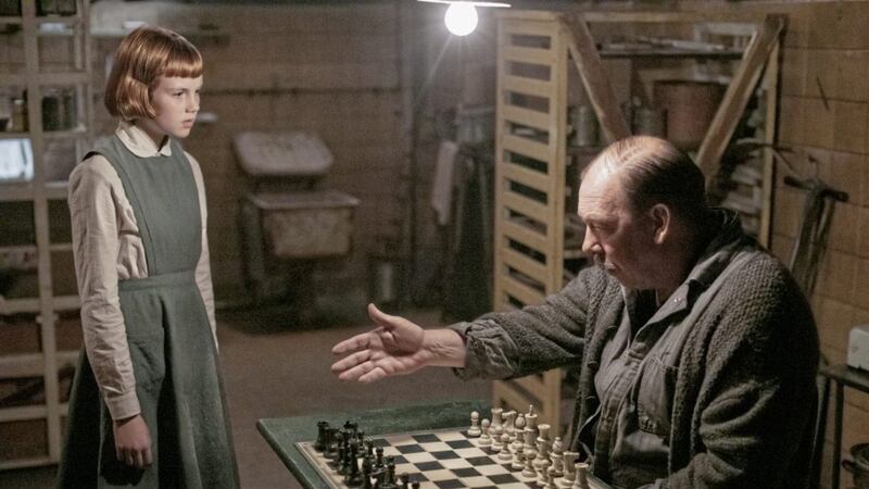 Isla Johnston, as the young Beth, is introduced to chess by Mr Shaibel (Bill Camp).  picture by PHIL BRAY/NETFLIX &copy; 2020 