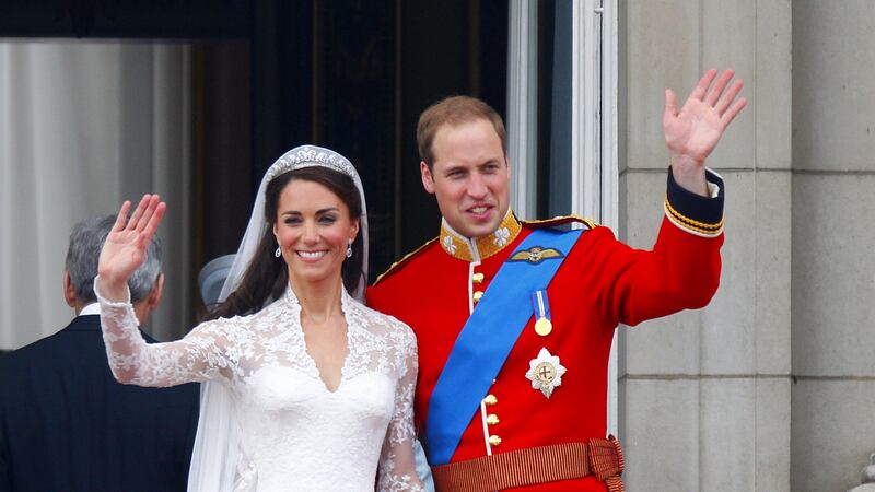 Prince William and his wife Kate wave to the crowds from the balcony of Buckingham Palace following their wedding at Westminster Abbey