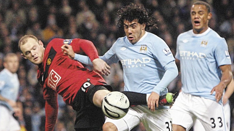 BIRTHDAY BOY: Manchester City's Carlos Tevez (centre) and Manchester United's Wayne Rooney (left) battle for the ball during the Carling Cup semi-final first leg match at the City of Manchester Stadium Manchester on Tuesday January 19 2010. Picture by Dave Thompson/PA Wire.