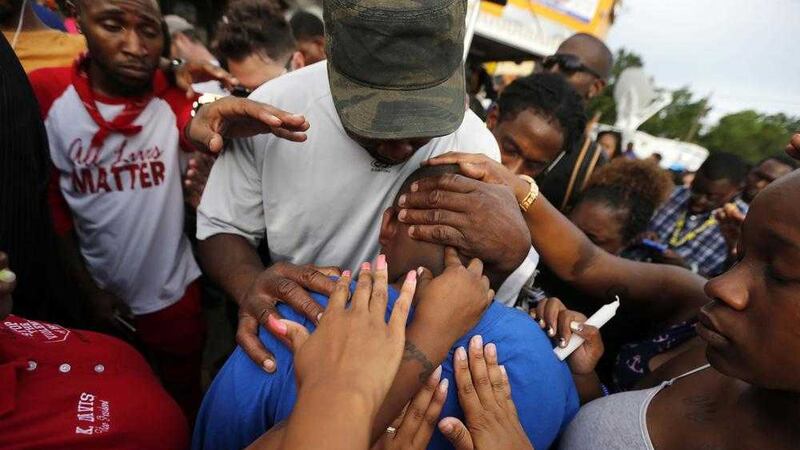 Cameron Sterling, son of Alton Sterling, is comforted at a vigil outside the Triple S convenience store in Baton Rouge on Wednesday PICTURE: Gerald Herbert/AP 