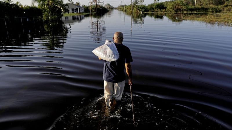 Jean Chatelier walks through a flooded street from Hurricane Irma Picture: David Goldman/AP 