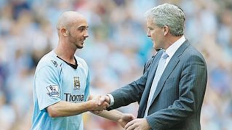 Manchester City's Stephen Ireland shakes hand with manager Mark Hughes