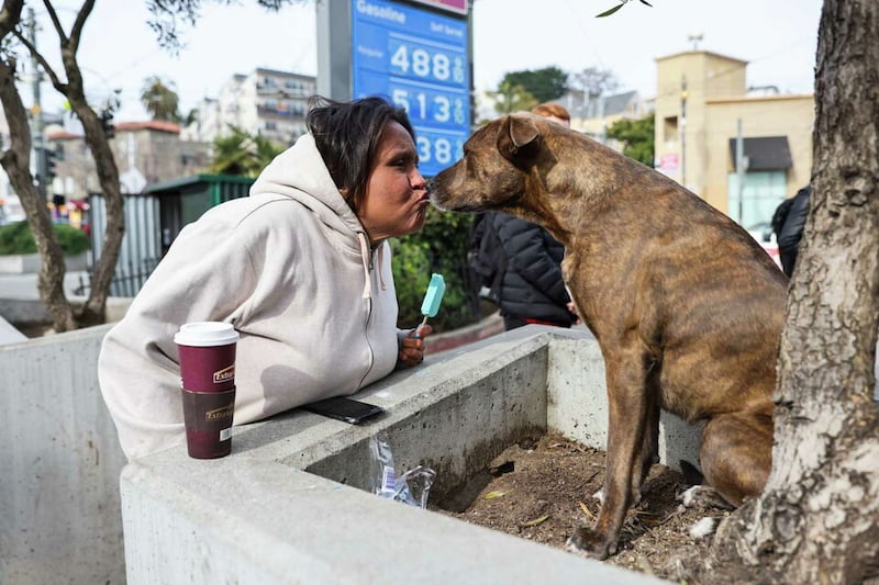 Victoria Solomon, 34, who lives in a hotel but has been homeless since she was 16, kisses her dog, Chunx, in San Francisco’s Castro neighborhood. Gabrielle Lurie/The Chronicle