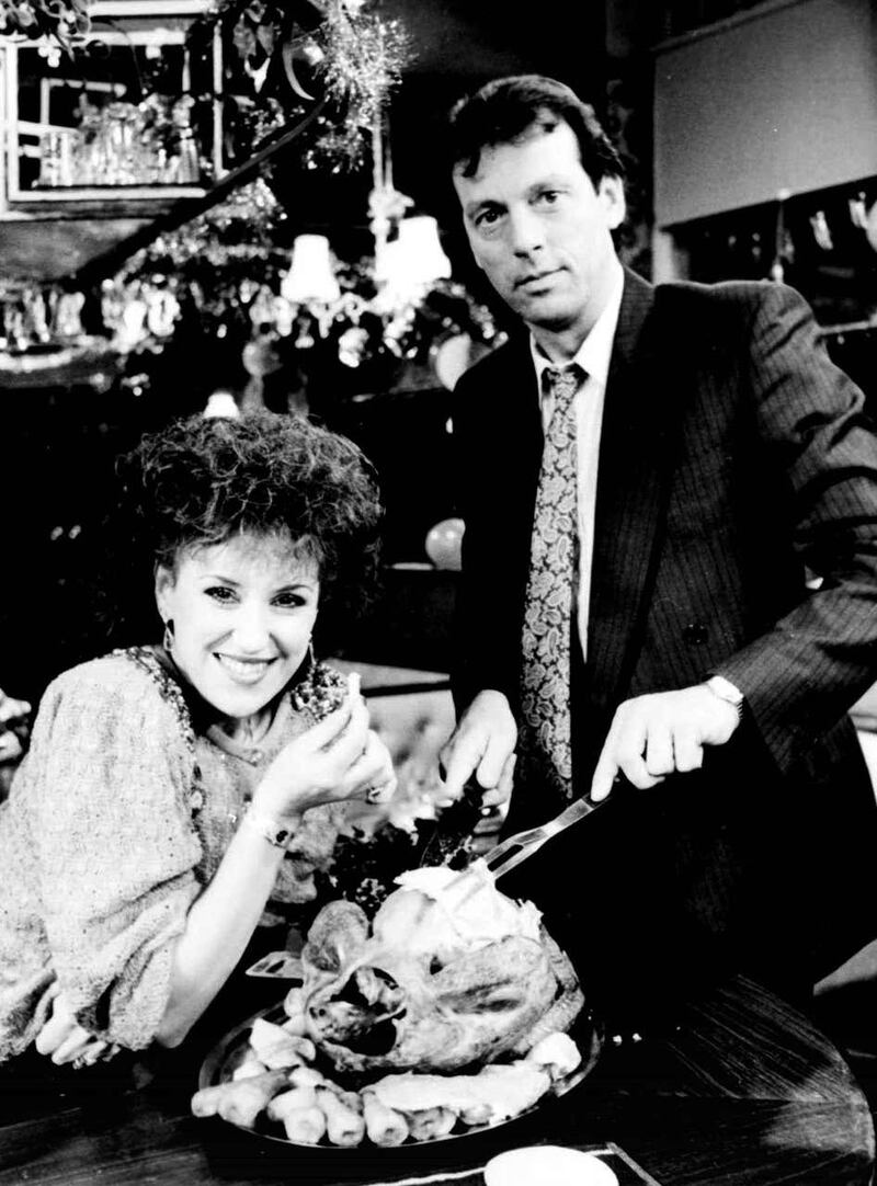 Queen Vic landlord Den Watts (Leslie Grantham) and on-screen wife Angie (Anita Dobson) carving the Christmas turkey (PA)