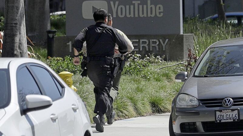 Officers run toward a YouTube office in California following reports shots had been fired. Picture by Jeff Chiu, Associated Press 