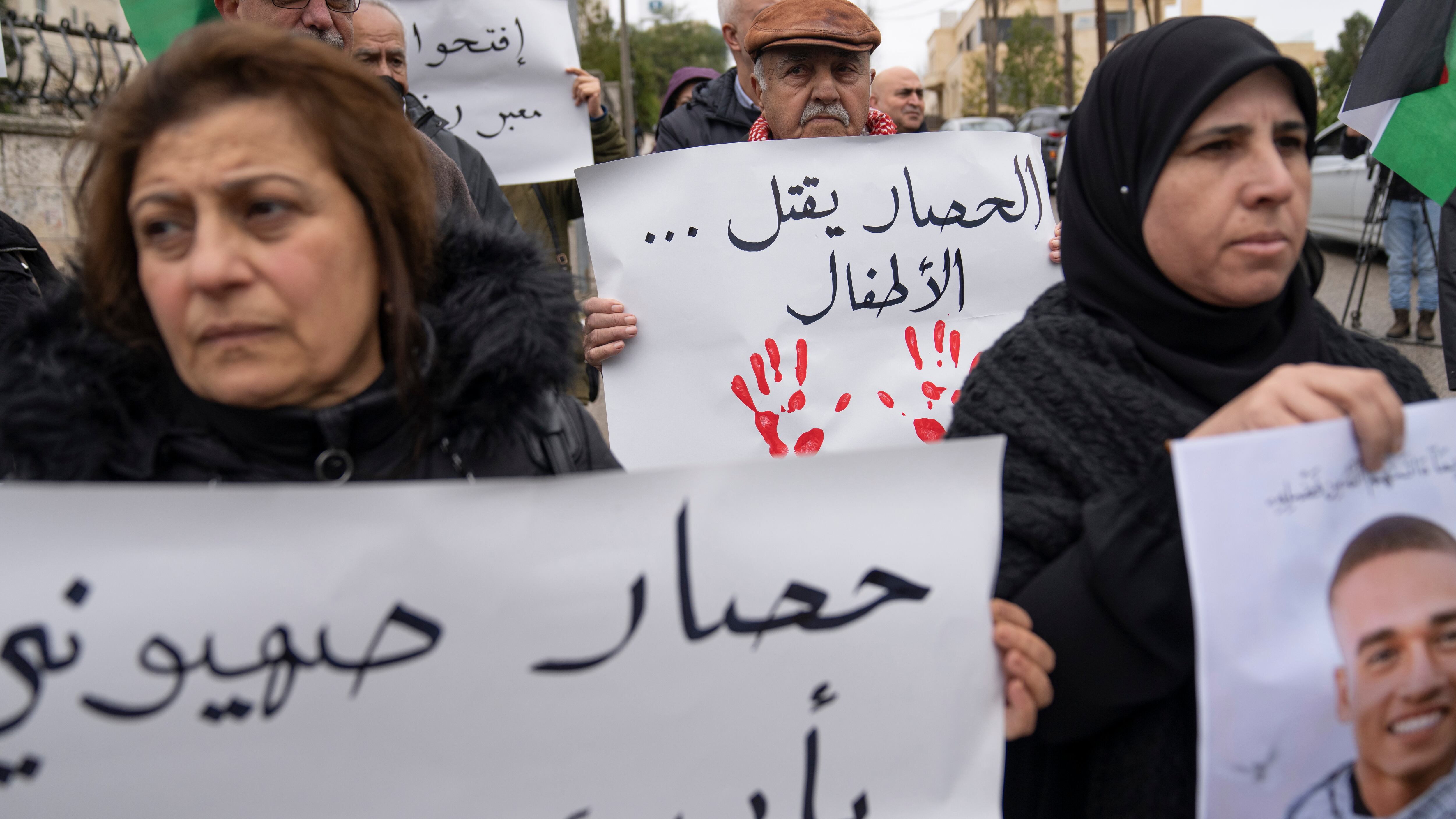 Palestinian activists carry posters, one reads ‘the siege is killing the children’ while protesting in front of the Egyptian embassy, in the West Bank city of Ramallah (Nasser Nasser/AP)