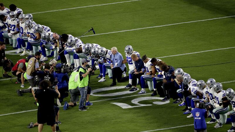 The Dallas Cowboys, led by owner Jerry Jones, centre, take a knee prior to the national anthem prior to an NFL football game against the Arizona Cardinals, on Monday. Picture by Matt York, Associated Press&nbsp;