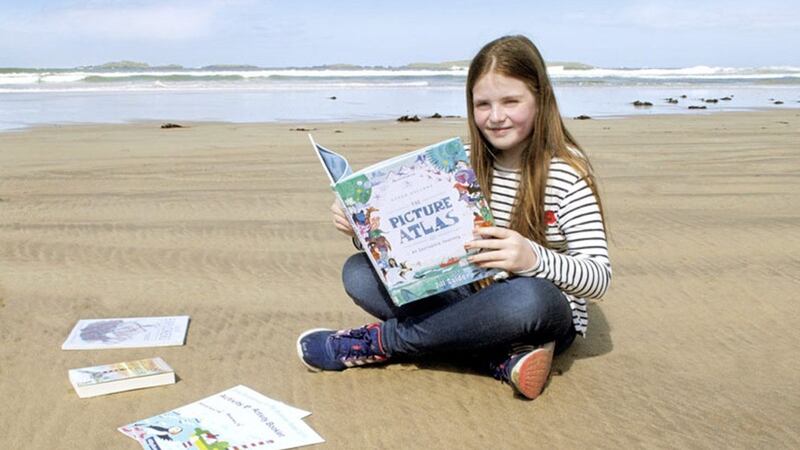 Mya, from Kells, getting ready for the Libraries NI Big Summer Read during a visit to Portrush East Strand Beach 