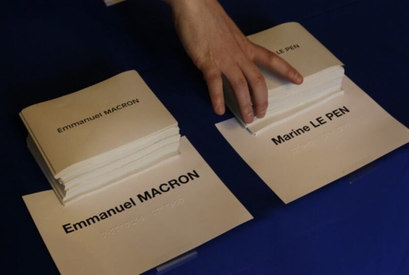 Ballot papers for the French presidential election are prepared in a polling station in Paris, Sunday, May 7, 2017.