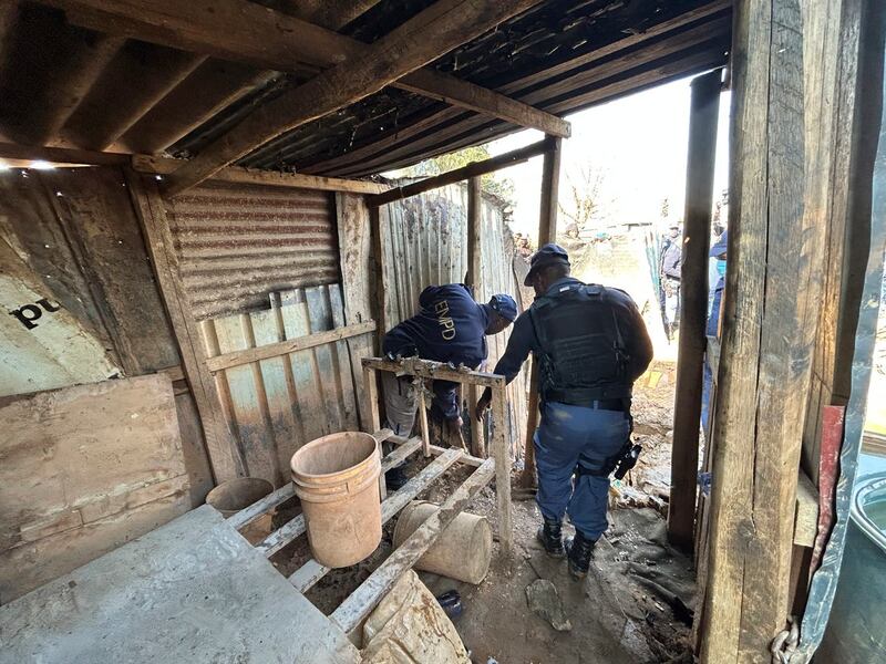 Police officers dismantle a shack