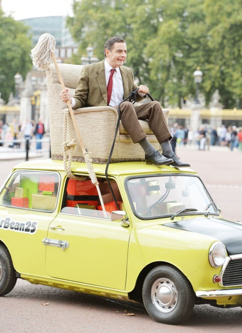 Mr Bean, played by Rowan Atkinson, celebrates the character's 25th anniversary on The Mall in front of Buckingham Palace, London, on his trademark Mini.